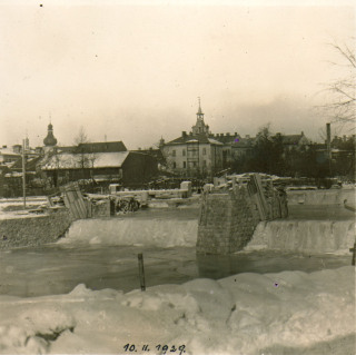 Fotografie . 12    Velk zima v roce 1929 peruila stavebn prce na regulaci eky. Snmek z 10. nora 1929 ukazuje zamrzlou Tichou Orlici a rozestavn pil budoucho vlcovho jezu u zmeck budovy. Vzadu je vidt radnin budova a vce nalevo barokn zvonice. (zdroj: Archiv Orlickho muzea v Chocni