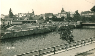 Fotografie . 24    S regulac Tich Orlice v letech 19281931 dolo i ke zzen novho nho koupalit o vodn ploe cca 5 000 m2, s hloubkou vody asi 1,15 m (nazvno rovn Chocesk Ostende). Toto mstsk n koupalit Na Ostrov architektonicky navrhl brnnsk profesor architektury Adolf Liebscher (18871965). O podob nho koupalit vypovdl tehdej mstsk kronik Ladislav Prak v roce 1964 nsledujc informace: Kdy se v obdob prvn republiky provdla regulace Orlice, nov plovrna se vybudovala za kinem. V doln ece pod nov vybudovanm splavem byla voda zadrena stavidly asi do ve jednoho metru. Tam byl pstup do vody po schodech a voda v ece byla o nco teplej ne na horn ece...   V padestch letech minulho stolet byla tato plovrna z hygienickch dvod pro nadmrn ptok kanalizanch splaek zruena. Chocesk veejnost si musela na veejn koupn pokat a do ervence 1967, kdy bylo slavnostn oteveno nov koupalit v mstsk sti Spoilov. (zdroj: Archiv Orlickho muzea v Chocni)