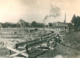 Fotografie . 04    Fotografie je ze srpna 1928. Potek regulace eky si vydal mnoho ppravnch prac. Na snmku je vidt nosn konstrukce pro stavenitn drku, po kter se odvel i navel materil. Vzadu je lokalita Na Herznce. (zdroj: Archiv Orlickho muzea v Chocni)